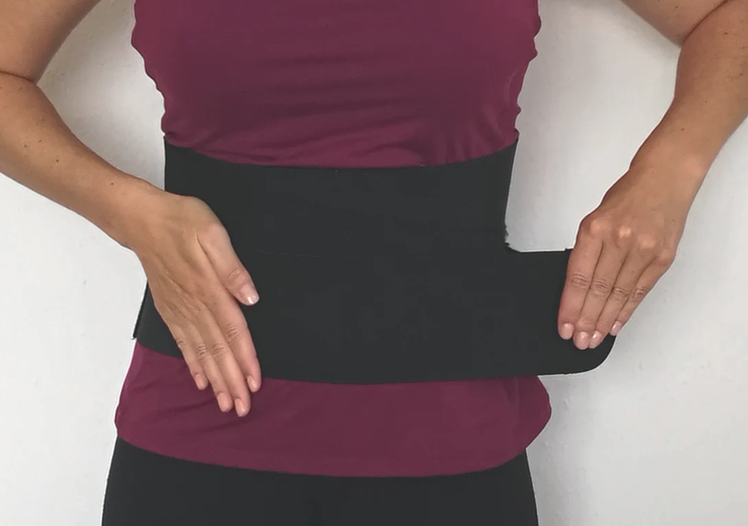 Ein angelegter Splint umschließt den Bauch mit breiten Stoffbändern.